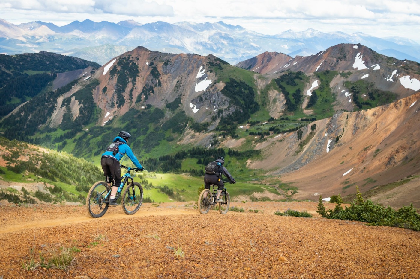 Cyclist on a dirt road through open terrain.