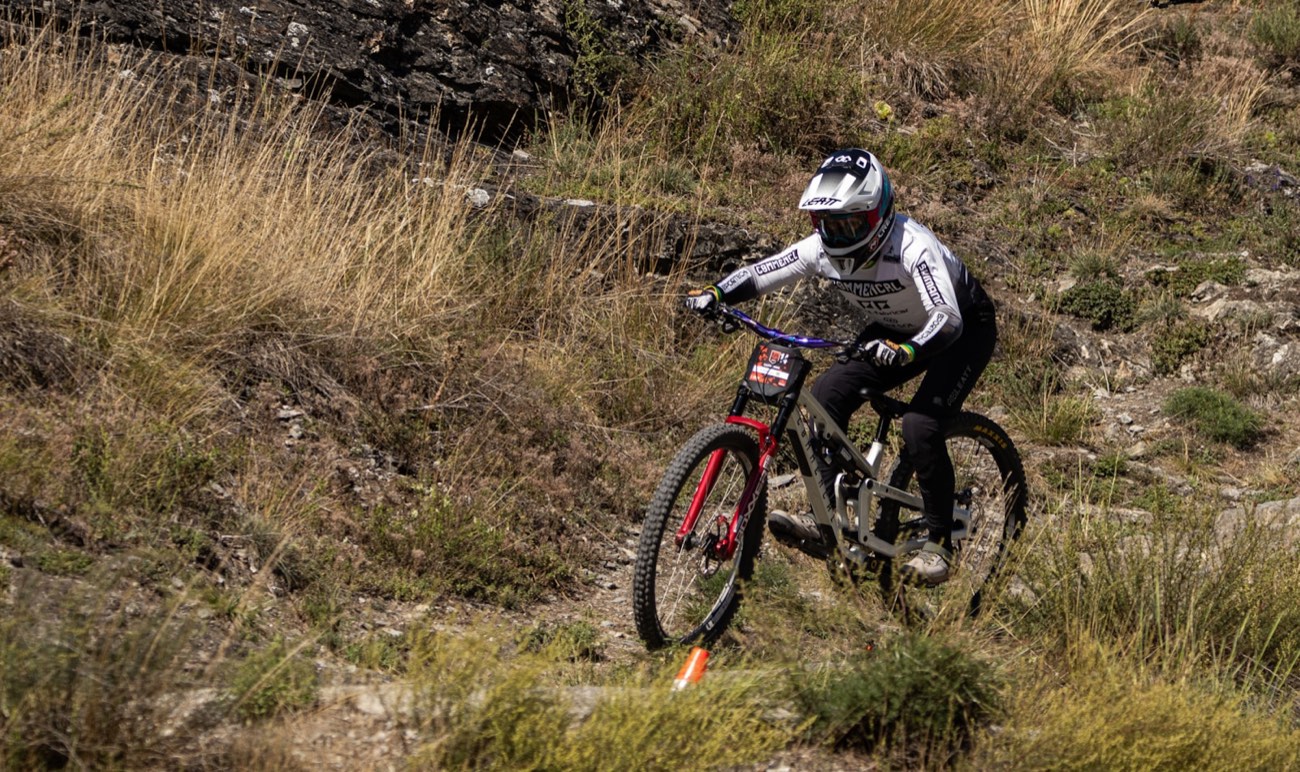 Mountain biker descending a grassy slope.