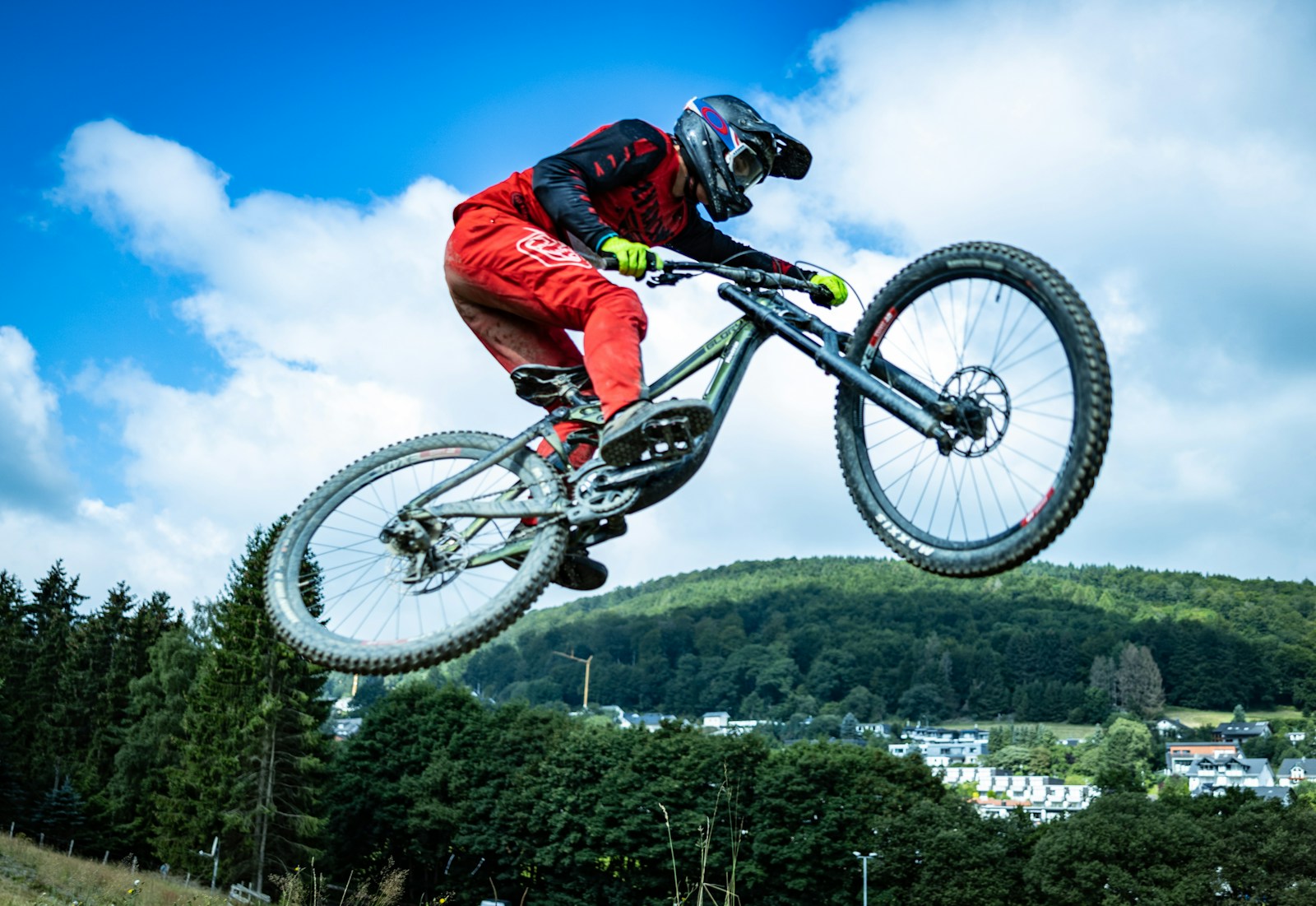 Cyclist in a red jacket riding a mountain bike.